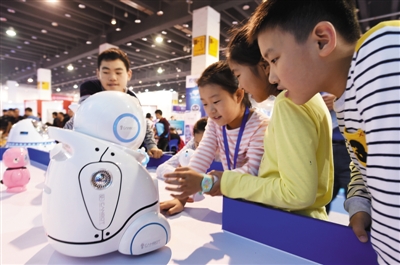 浙江省金华市,小朋友在与伙伴型家用机器人对话 浙江省金华市,小朋友在与伙伴型家用机器人对话