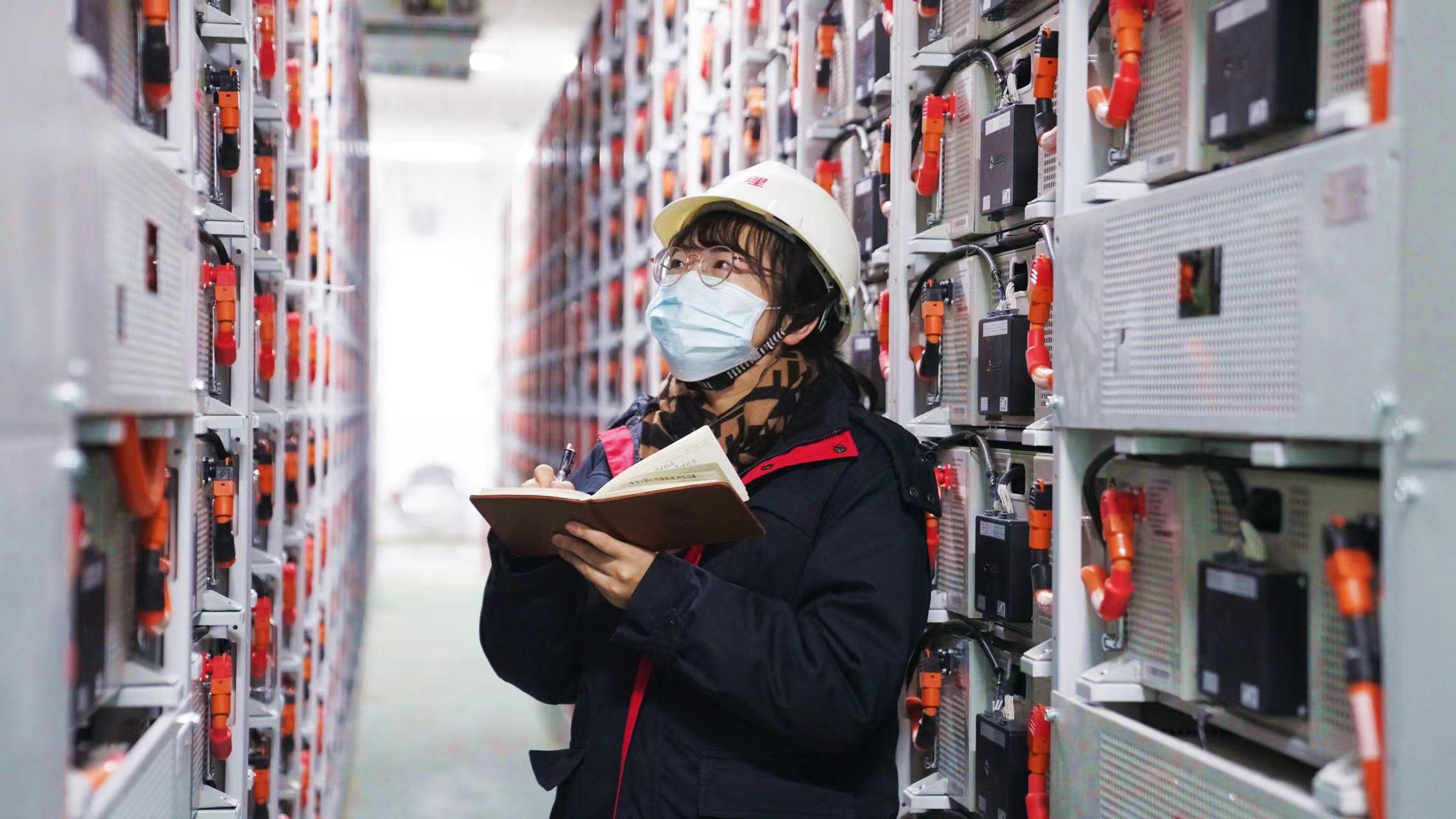 工作人员在共享储能电站内检查蓄电池运行情况 工作人员在共享储能电站内检查蓄电池运行情况